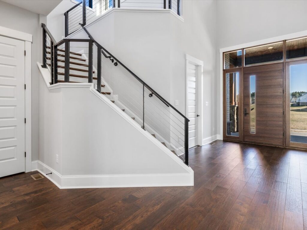 A large open foyer with hardwood floors and stairs.