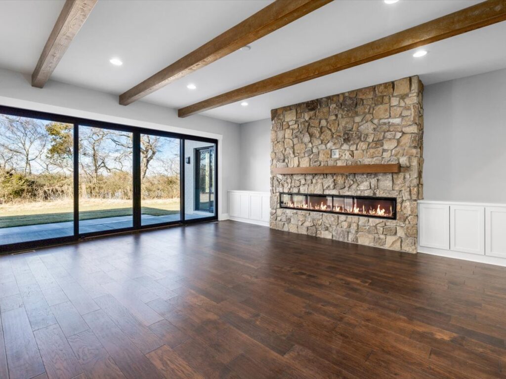 A living room with hard wood floors and stone fireplace.